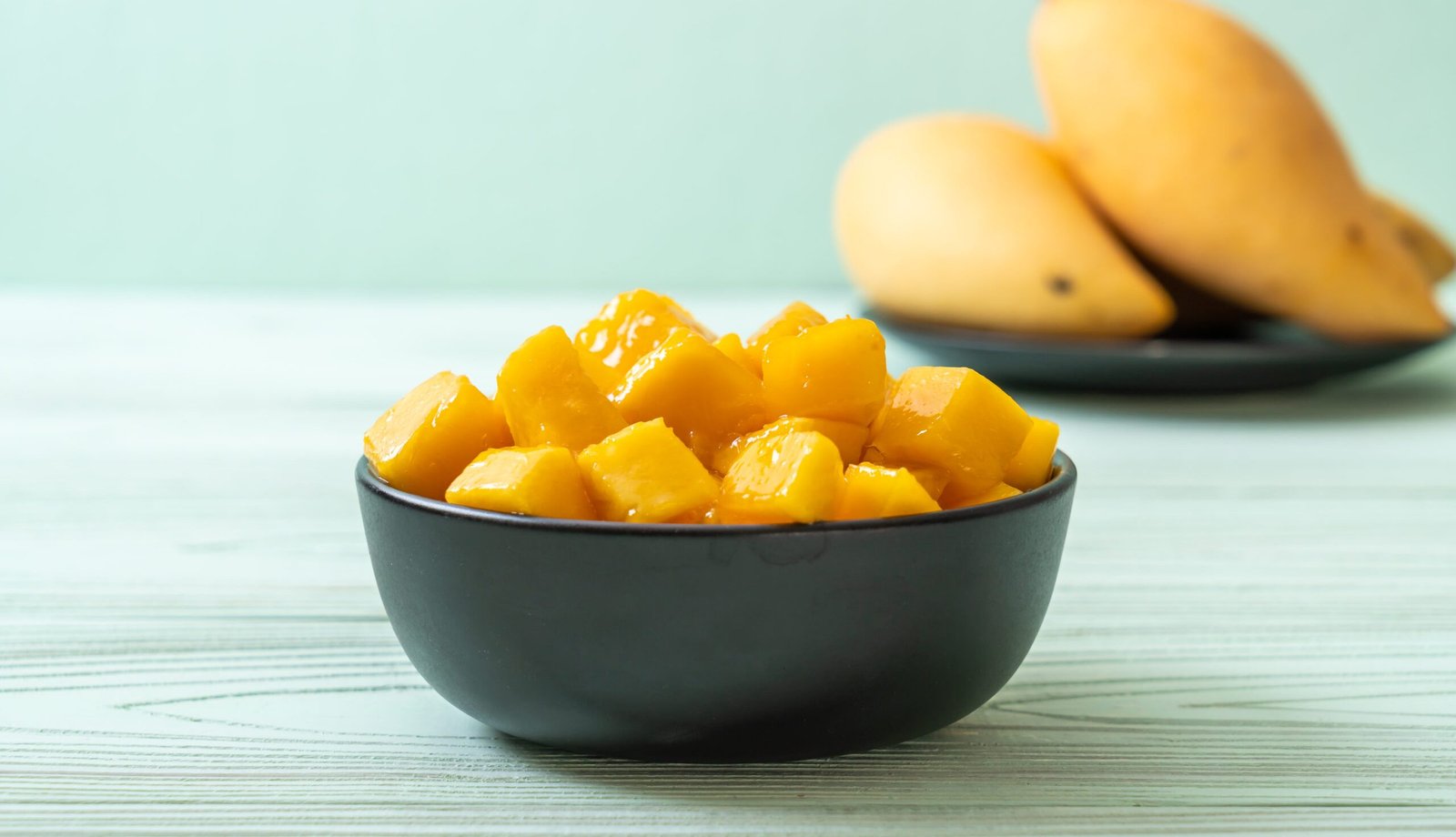 fresh and golden mangoes in bowl