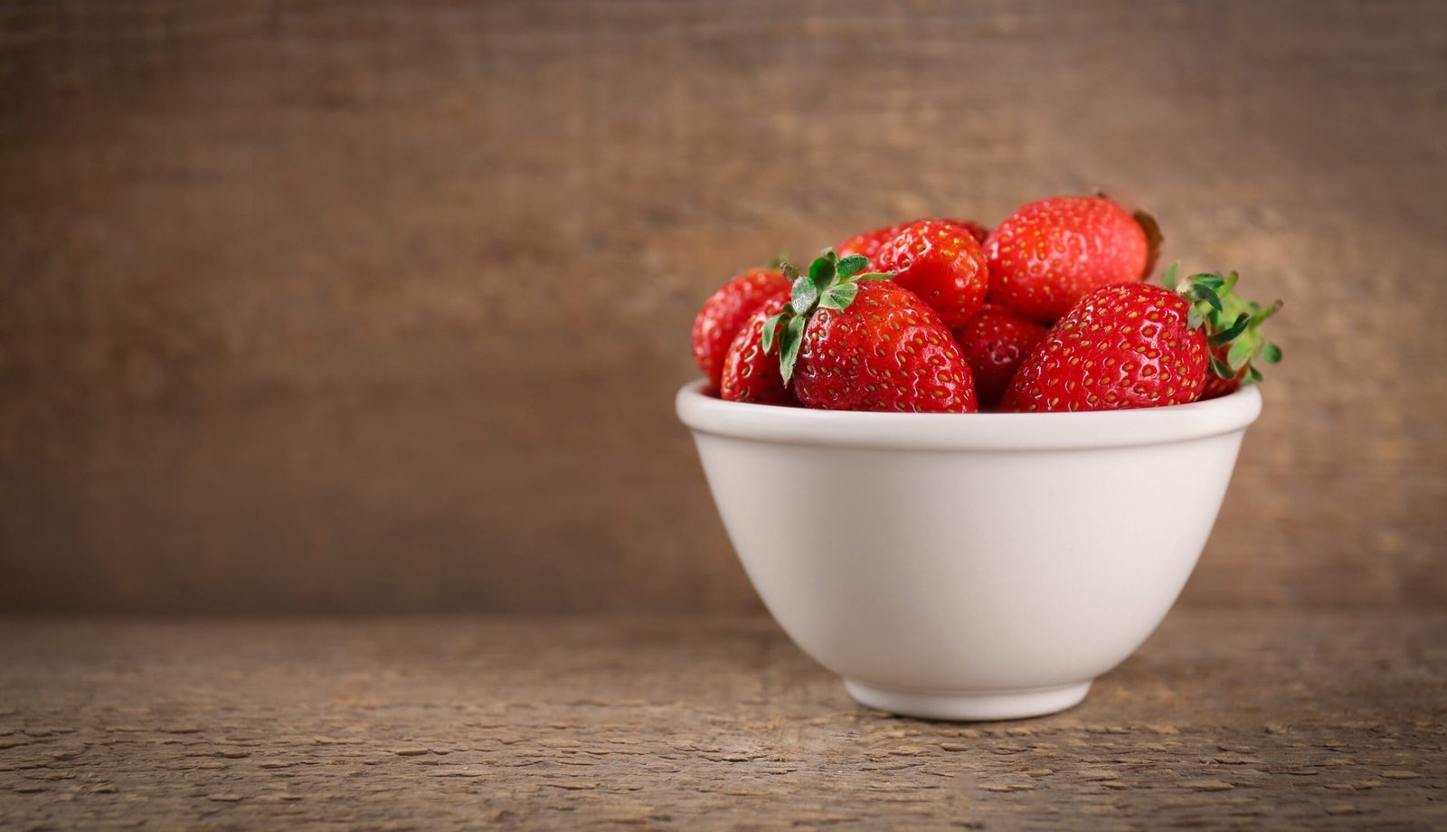 Fresh ripe strawberries in bowl on table
