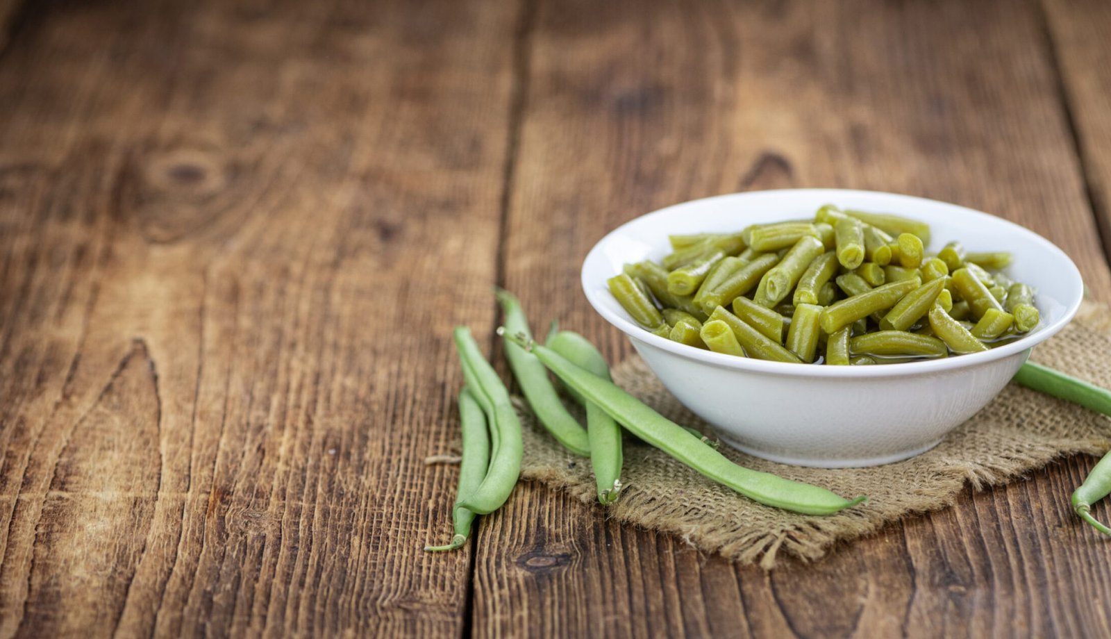 Preserved Green Beans as detailed close-up shot  (selective focus) on vintage background