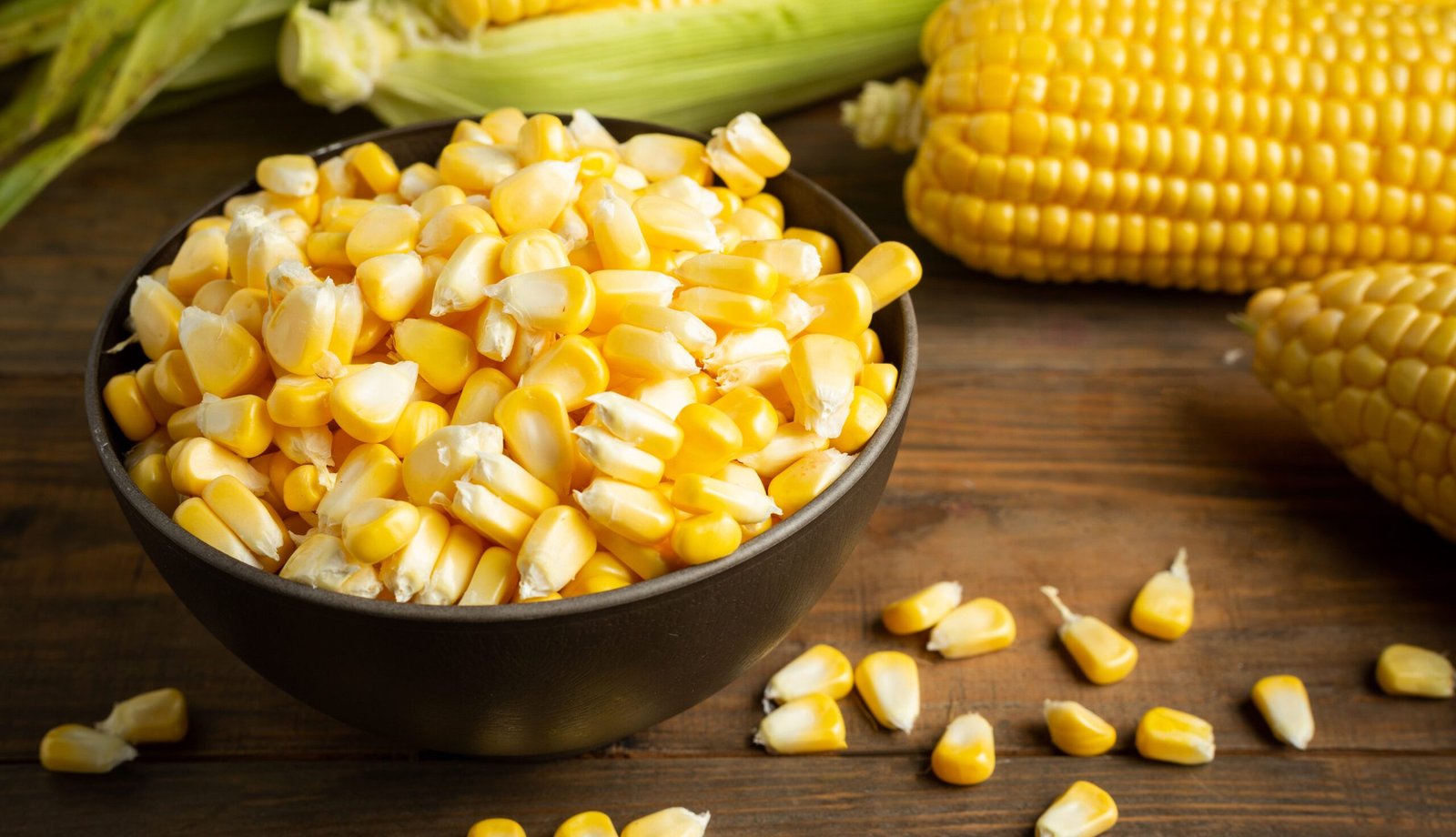 seeds and sweet corn on wooden table.